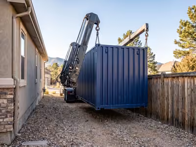 Side-lifter truck lowering a container into a side yard